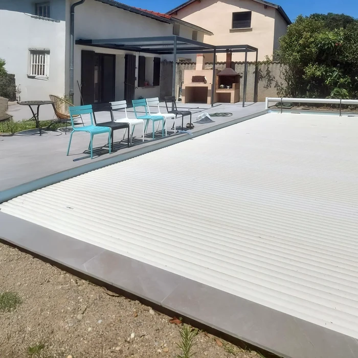 Terrasse extérieure moderne avec piscine couverte par volet roulant automatique blanc