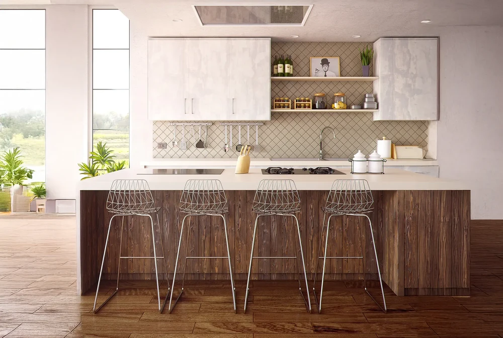 Cuisine moderne avec îlot central, quatre tabourets hauts filaires blancs, vue sur extérieur verdoyant par baie vitrée