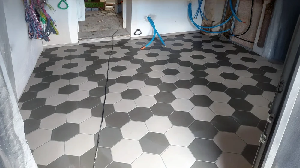 Chantier de rénovation intérieur avec pose de carrelage hexagonal en cours