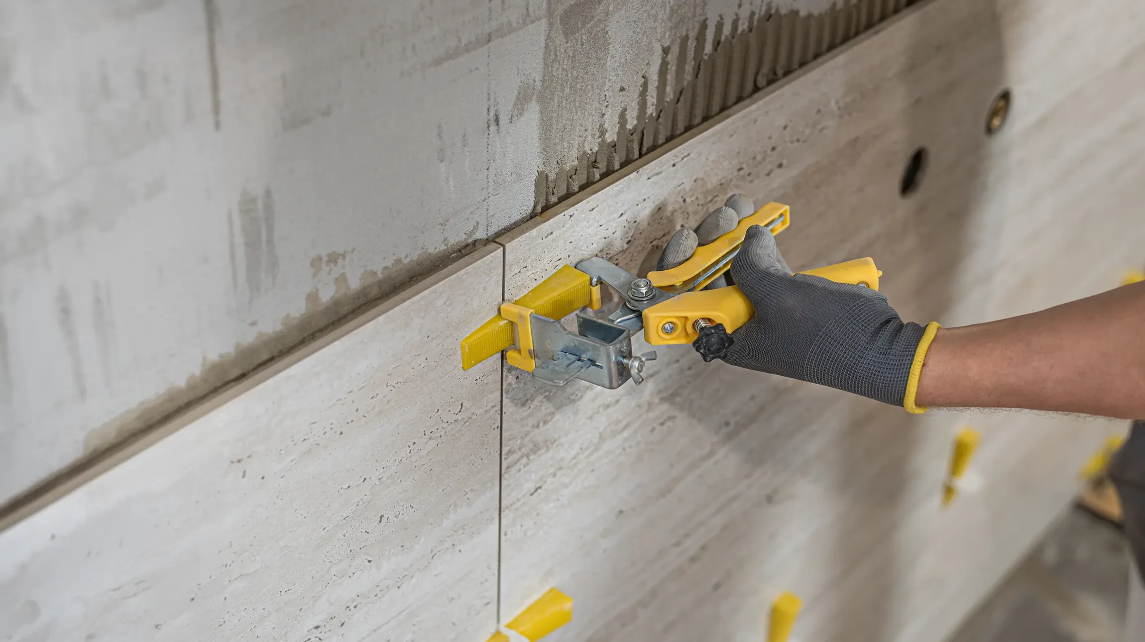 Carrelage en pierre naturelle grise disposé en damier régulier, surface murale ou sol intérieur